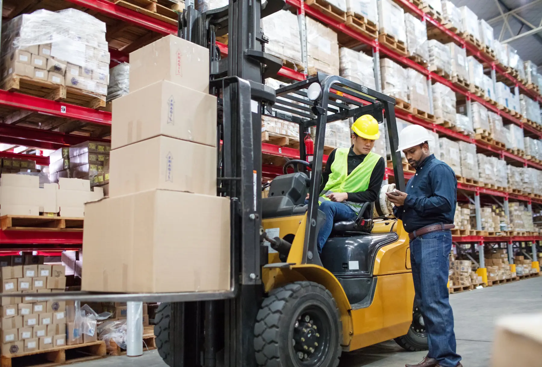 Supervisor checking a forklift operator in a warehouse